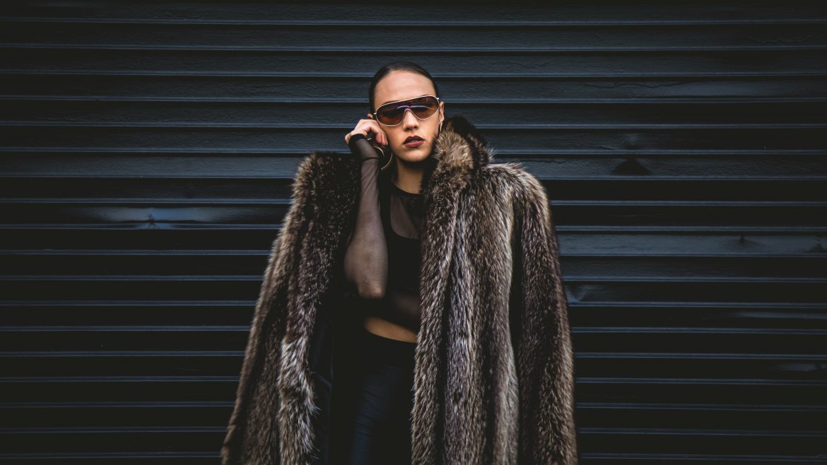 A woman in shades and coat looking stylish