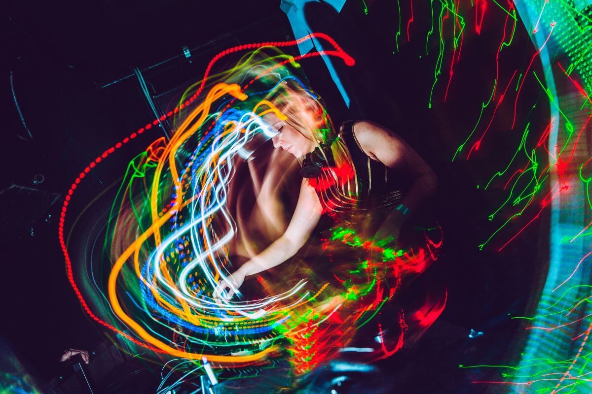 a picture of led lights circulating and a club dj playing in the center